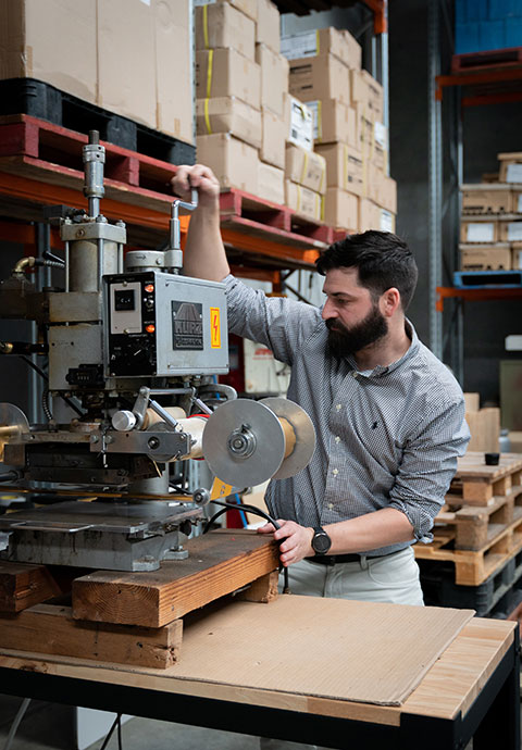Cody Group team member personalising merchandise on a hot-foil stamping machine